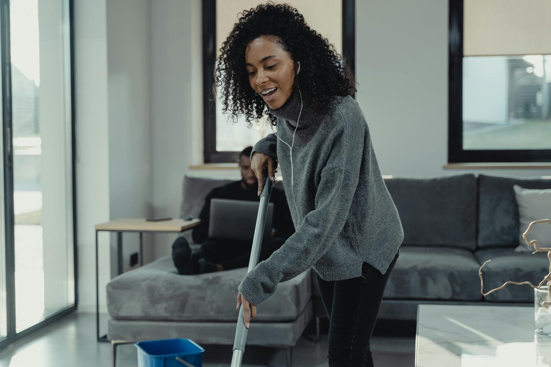 A professional house cleaner mopping the floor of a cozy Pennsylvania living room — Weekly Maid Service in Pennsylvania